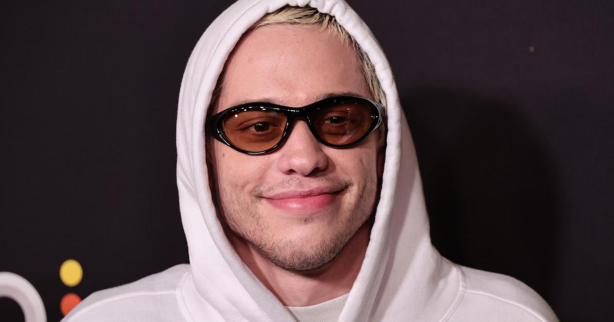 Pete Davidson wearing a white hoodie at an event.