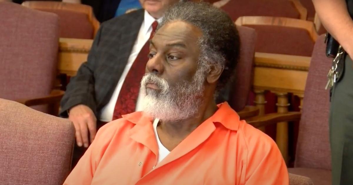 Nathaniel Cook sits in court wearing an orange jumpsuit