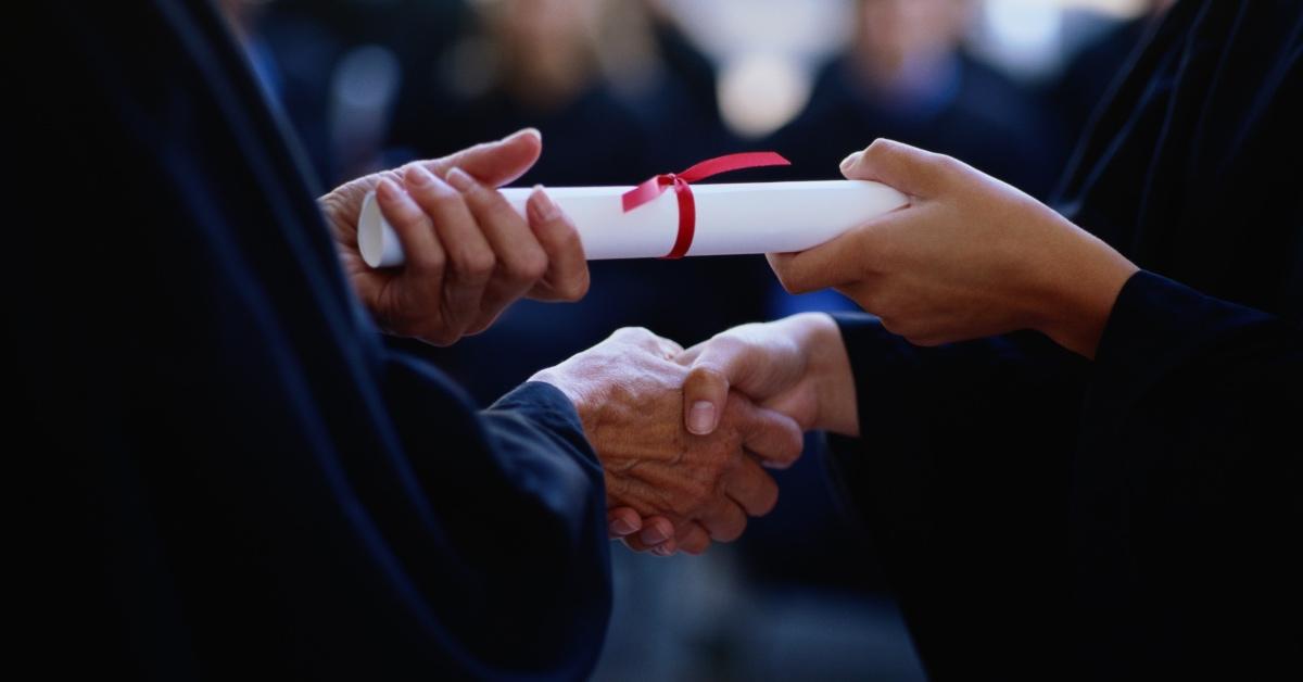 Photo of a young woman obtaining her college diploma for an expensive college degree.