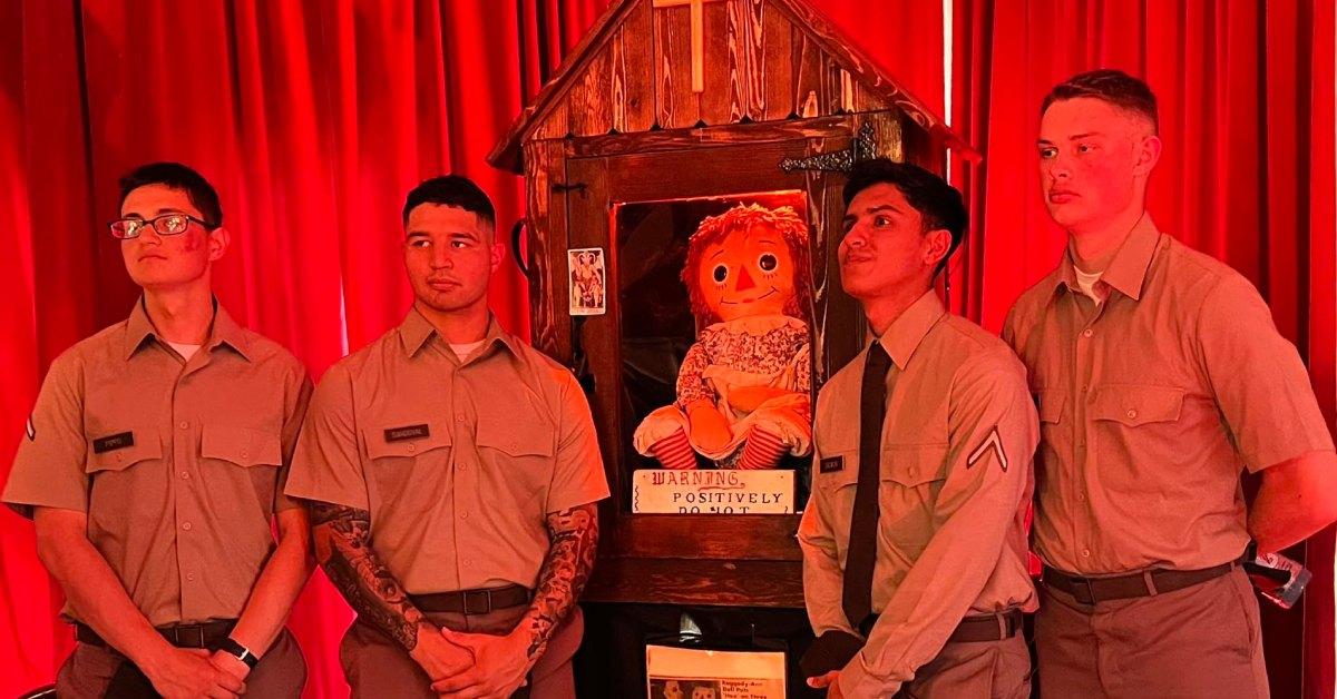 Service members pose with "haunted" Annabelle doll.