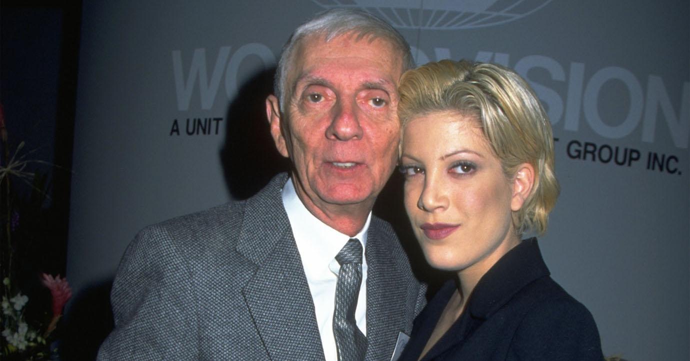 Tori Spelling seen with short hair and very 90s makeup on a red carpet alongside her father, Aaron, in 1999. 