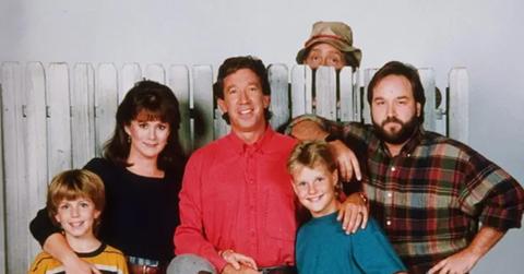 e Improvement' standing in front of a fence with Wilson behind it