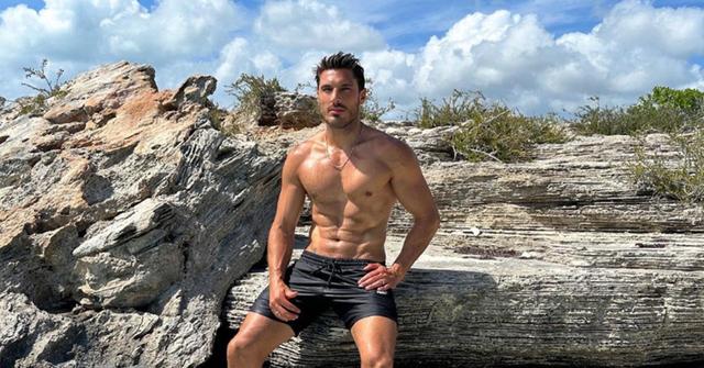 Chris Appleton sitting shirtless on some rocks