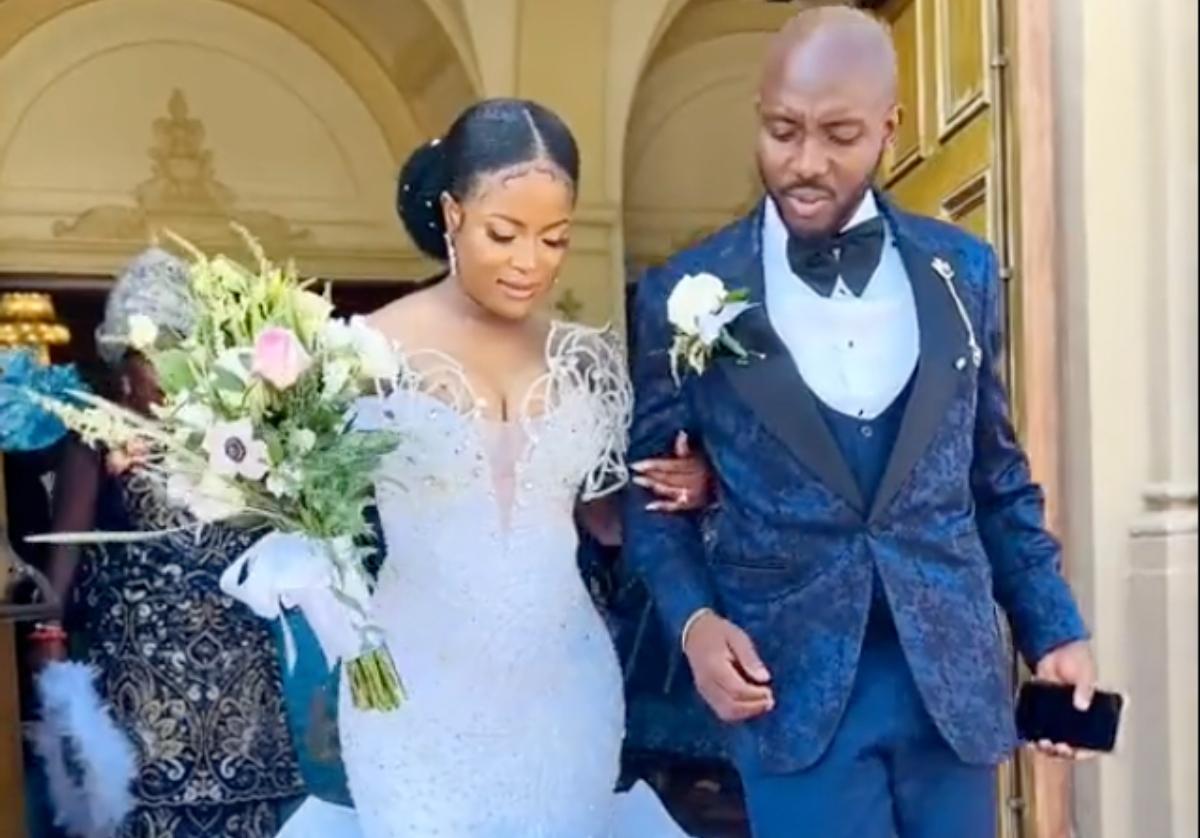 A man on phone wedding aisle with bride in front of the church