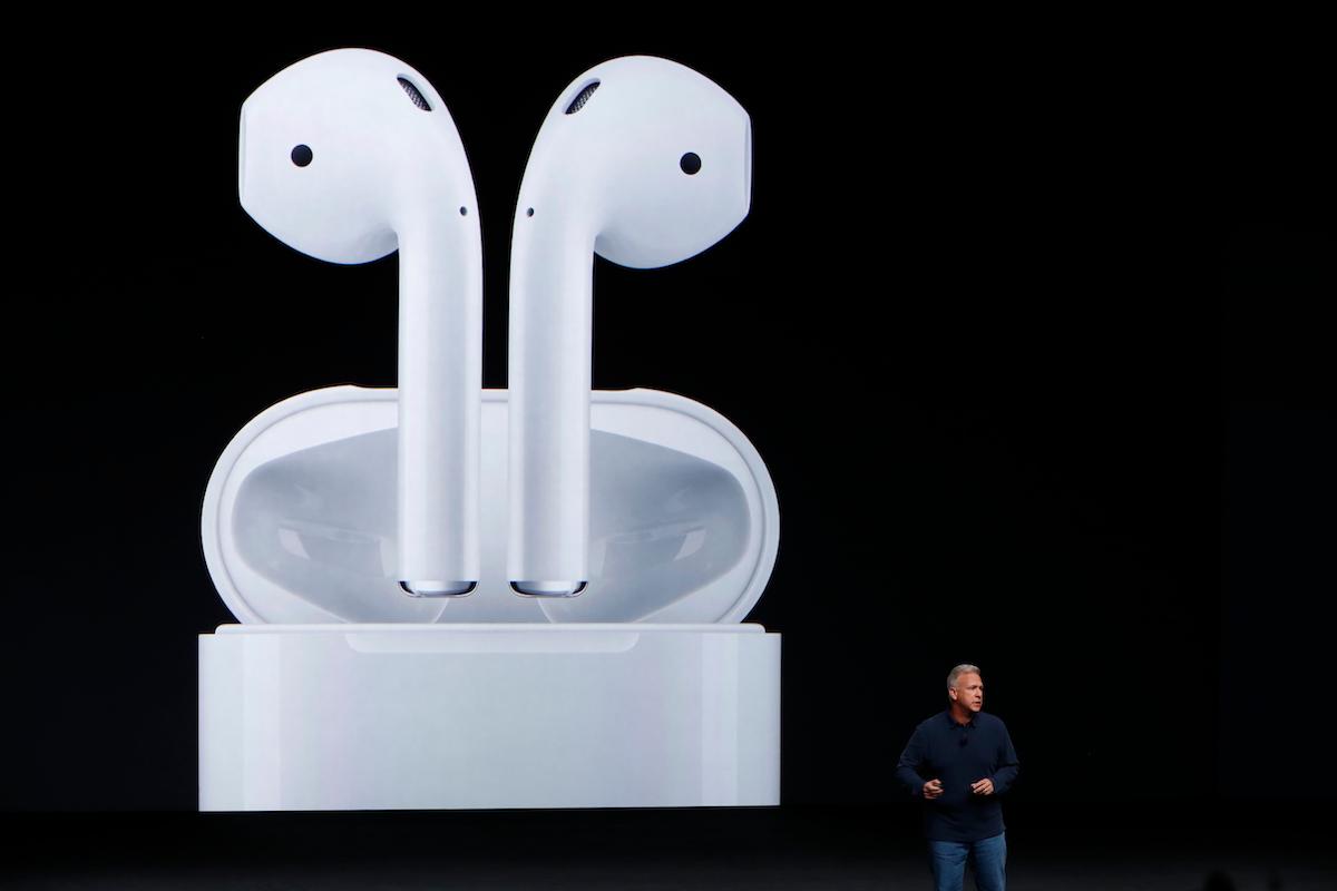 Phil Schiller standing next to giant image of Apple AirPods