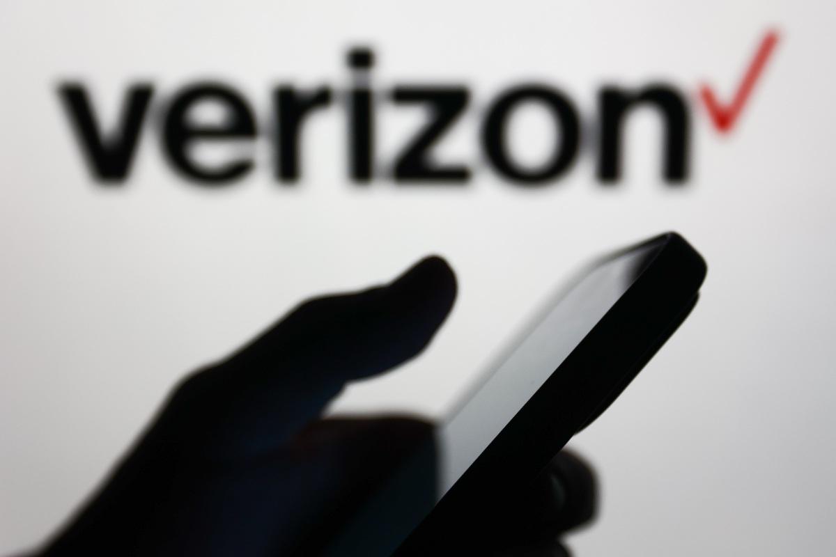 Verizon logo and a person holding a phone