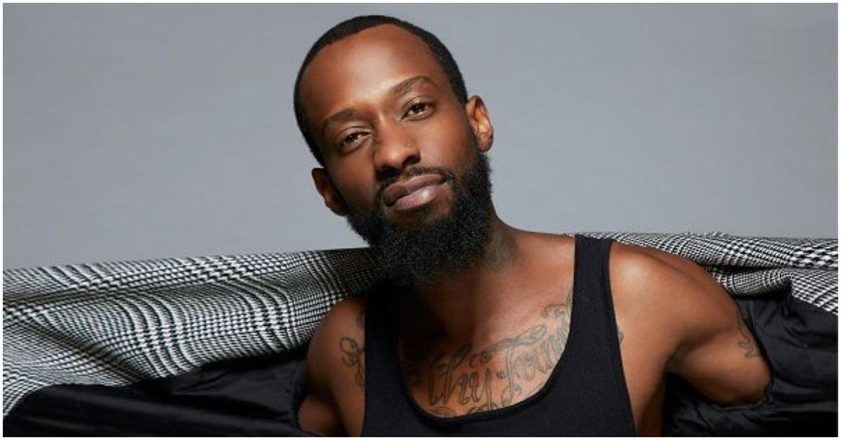 Walt from 'Black Ink Crew ' posing and holding his jacket in a promotional photo.