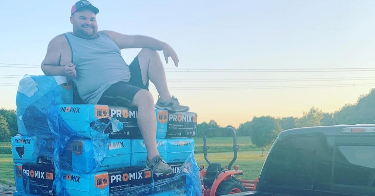 Gary Shirley sits on top of bags of mulch