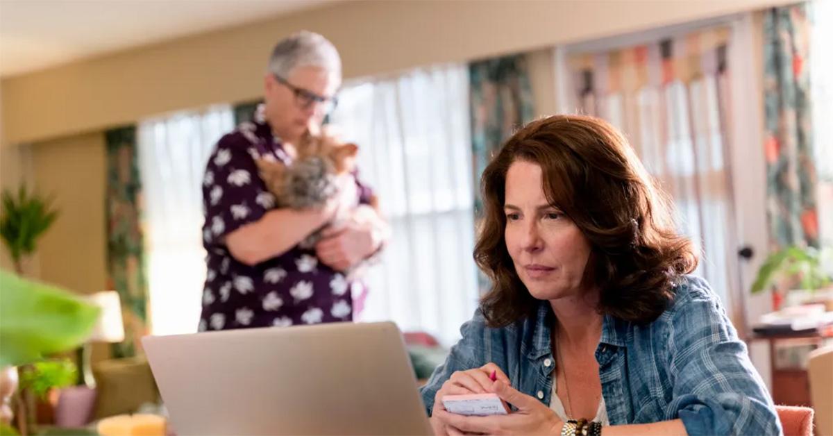 Robin Weigert sitting at a computer in 'Tracker.' 