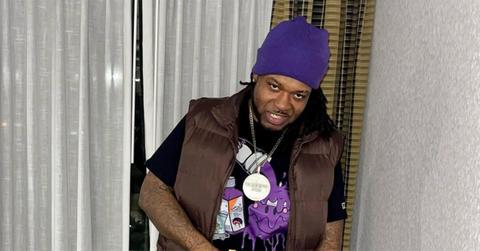 Travis Taylor posing in a brown vest and purple hat.