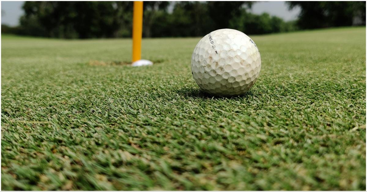 A golf ball near a hole