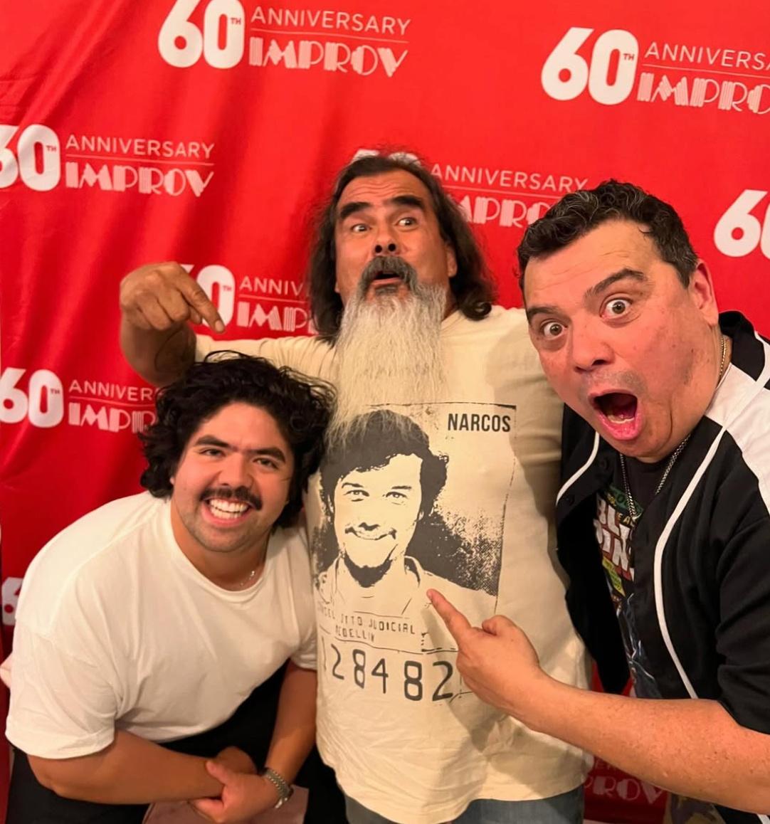 Carlos Mencia (right) posing with fans.