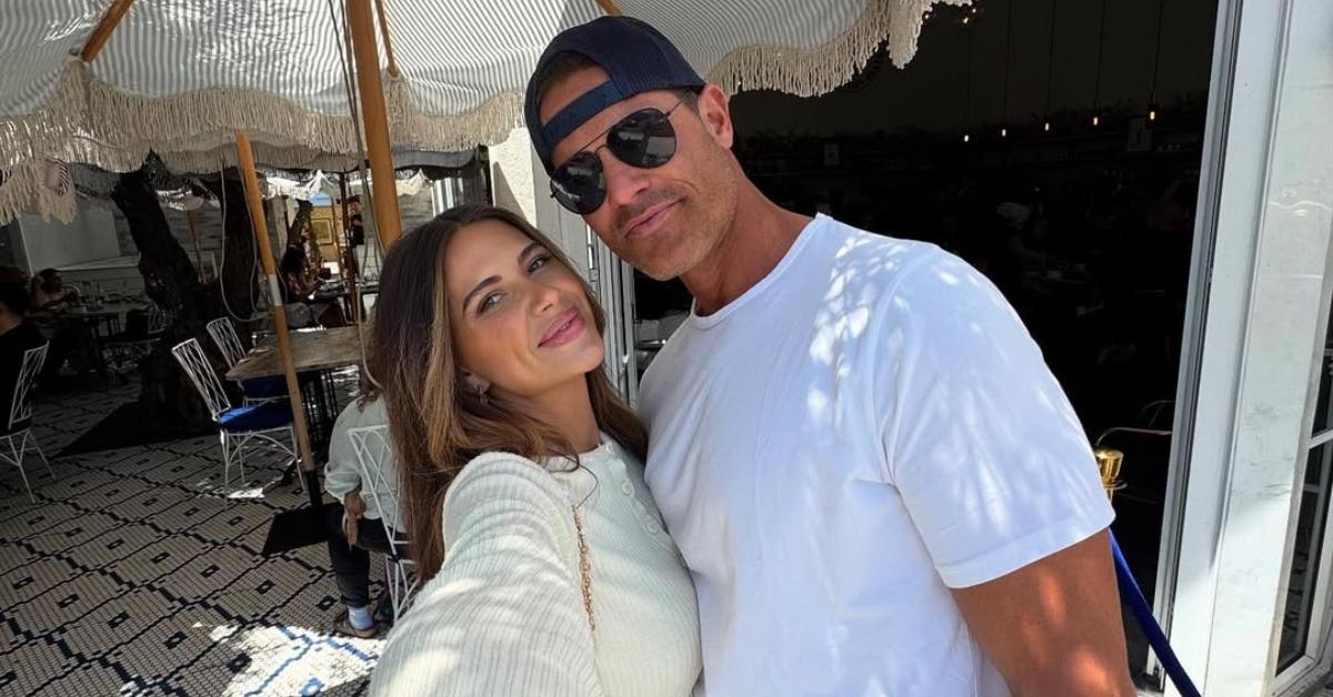 Bret and Demi take a selfie under an umbrella.