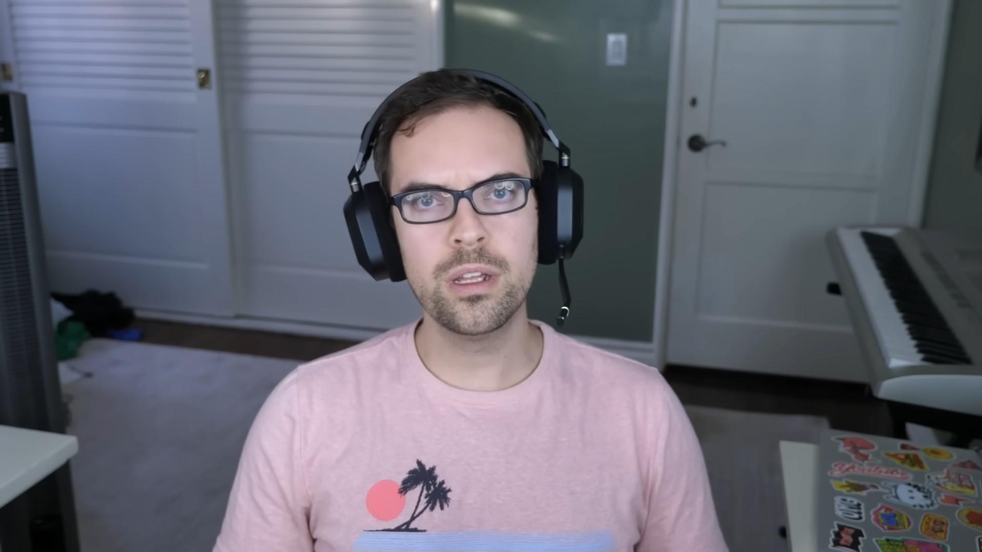 Image of Jacksfilms wearing a pink shirt and black headset.