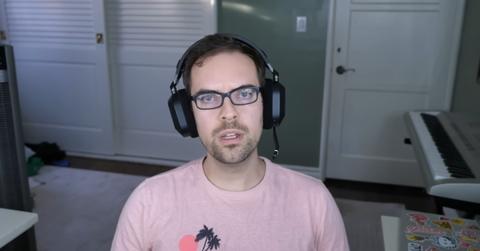 Image of Jacksfilms wearing a pink shirt and black headset.