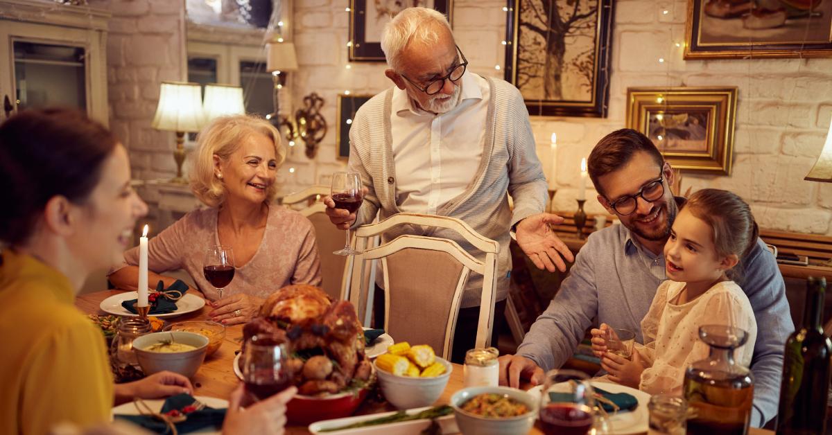 A family gathers around a table for their Thanksgiving feast.