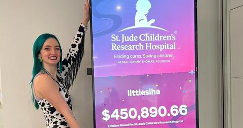 LittleSiha standing in front of her lifetime donations to St. Judes Hospital