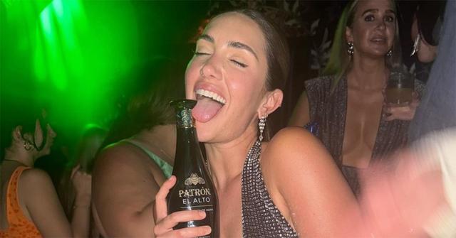 Tinx licking a bottle at a club in Miami.