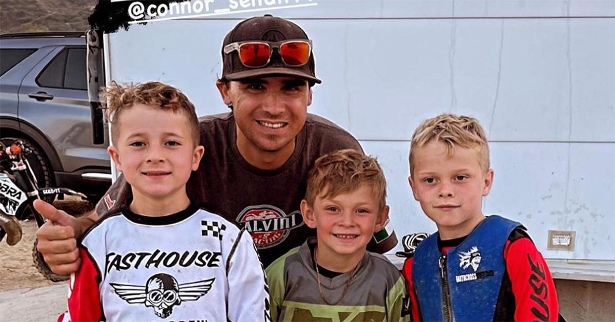 Jeff Alessi giving a thumbs up with three boys in front of him. 