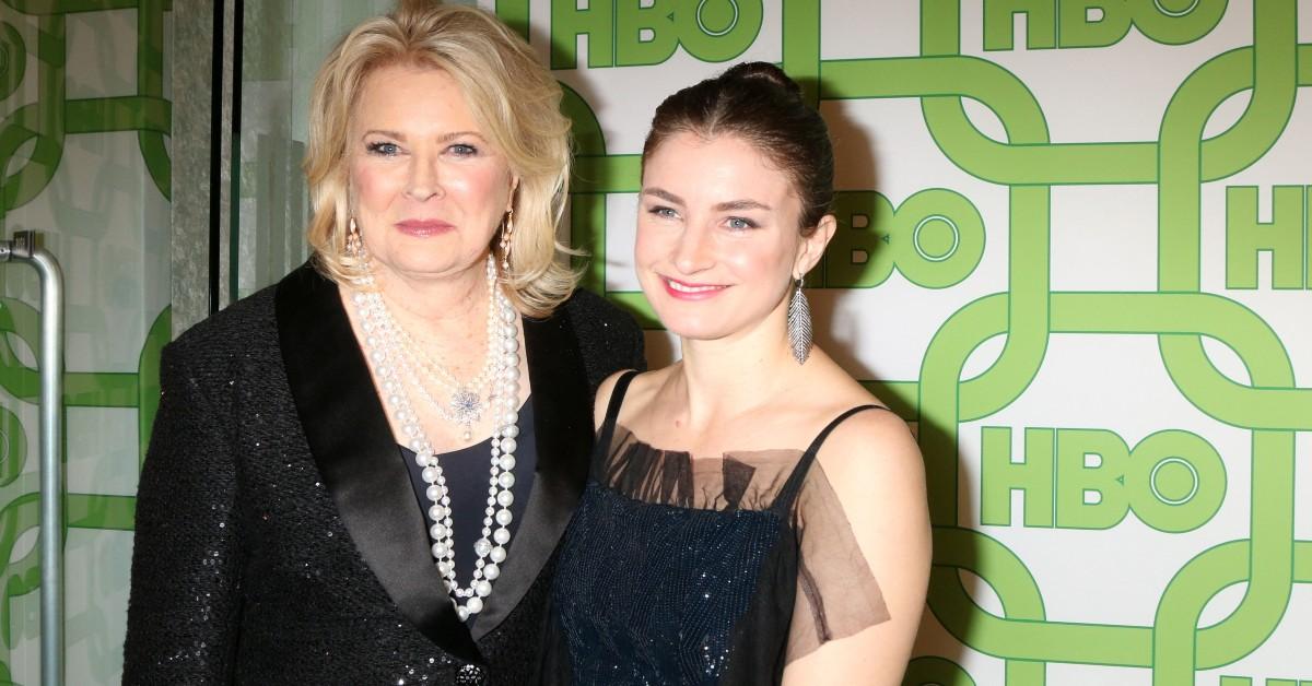 Chloe Malle posing with her mother at a press board
