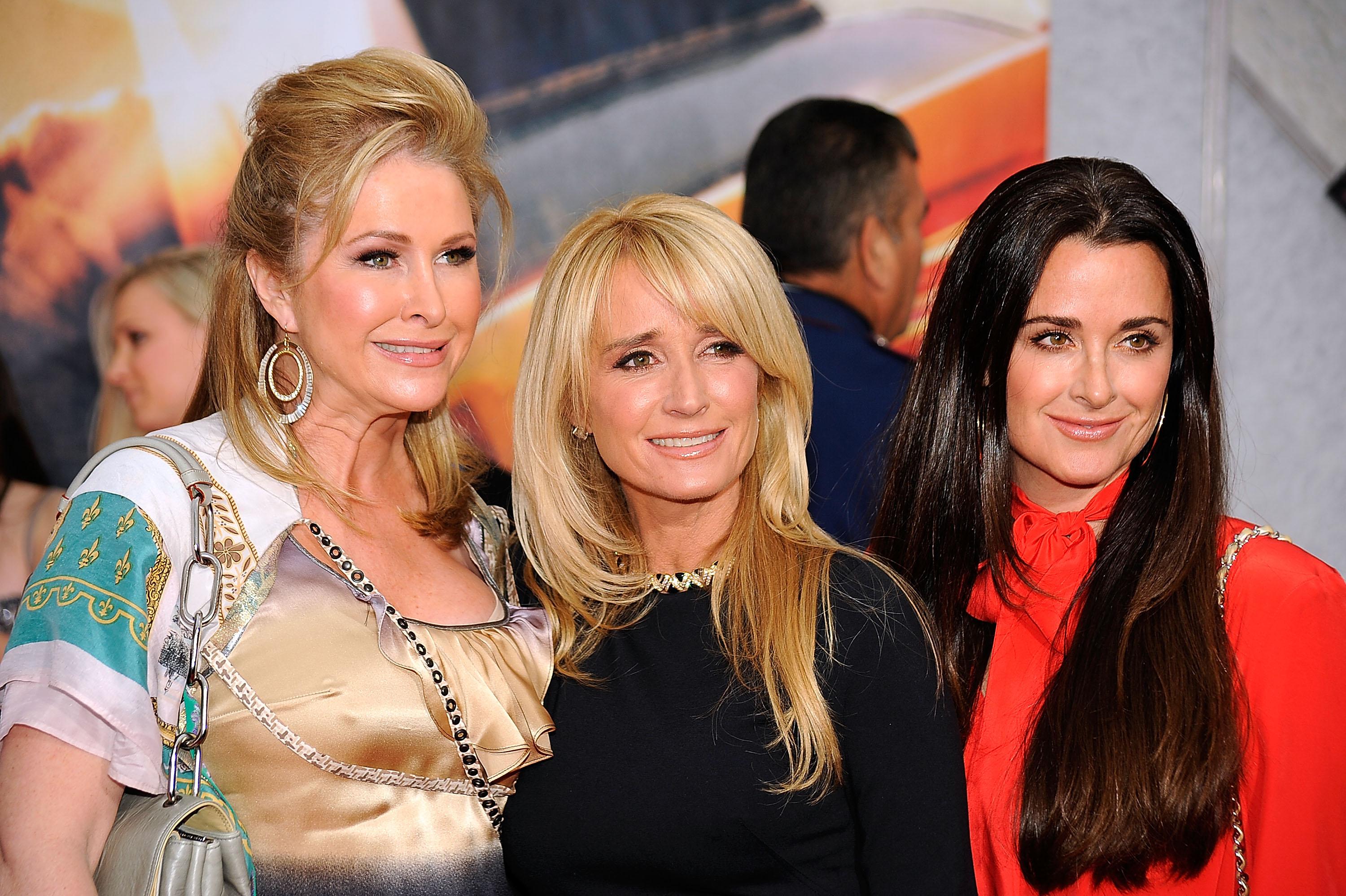 Kathy Hilton, Kim Richards, and Kyle Richards posing and smiling together. 