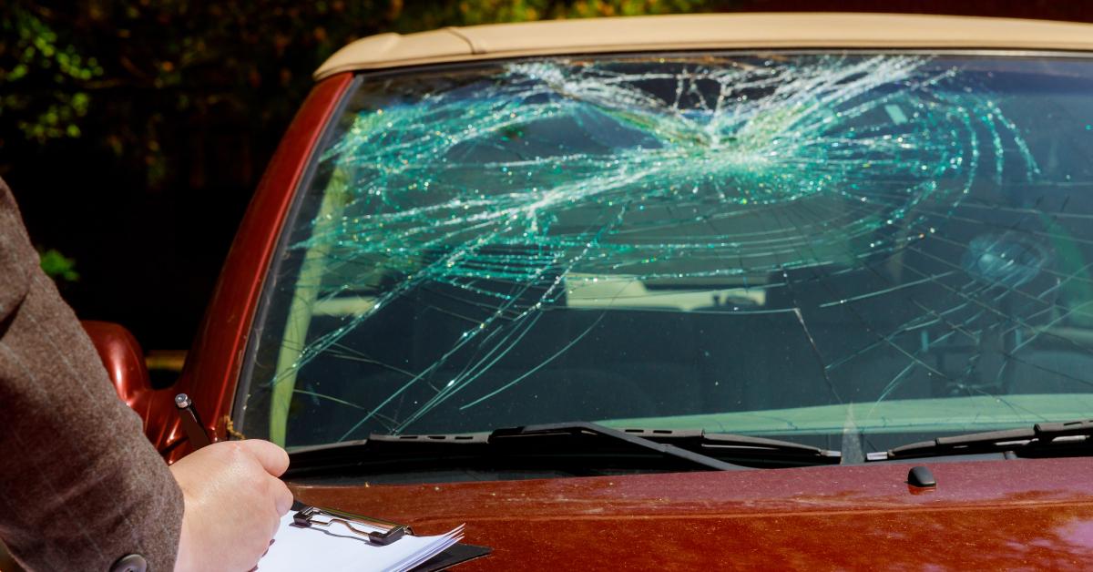 A red car with a cracked windshield.