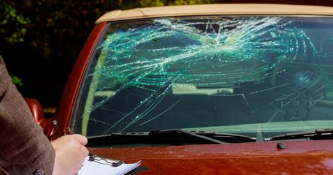 A red car with a cracked windshield.