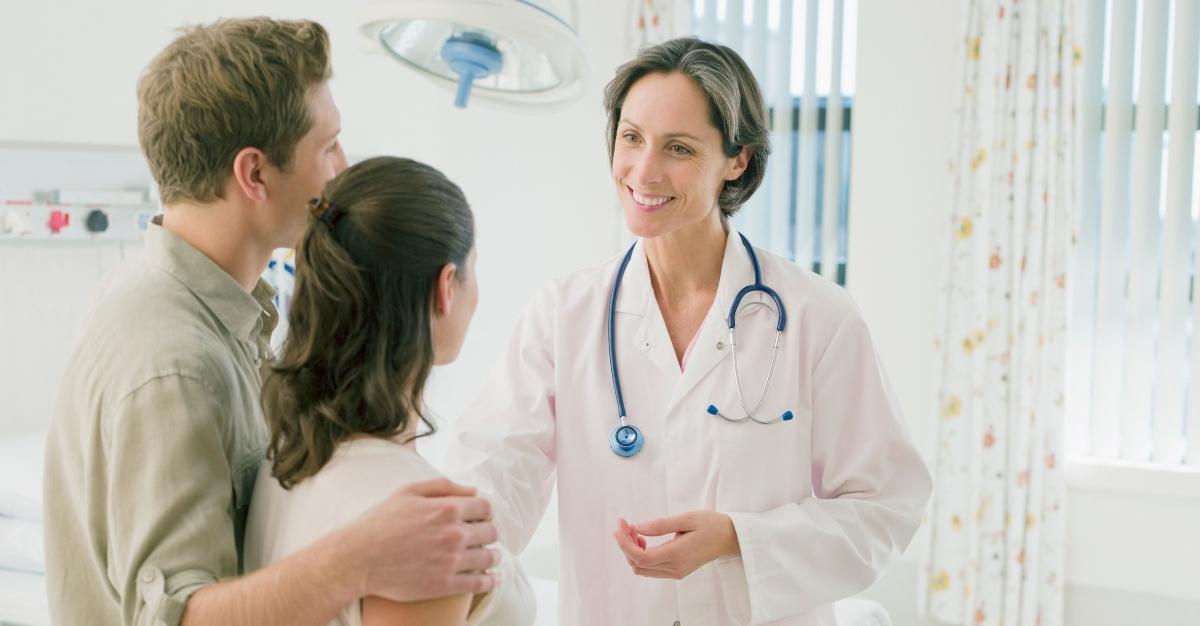 Pregnant woman and husband arriving in hospital - stock photo