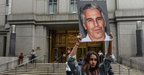 A protest group called "Hot Mess" hold up signs of Jeffrey Epstein in front of the federal courthouse on July 8, 2019, in New York City