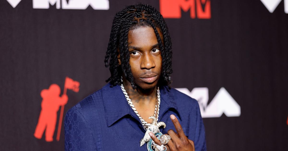Polo G throws up gang sign on the VMAs red carpet.