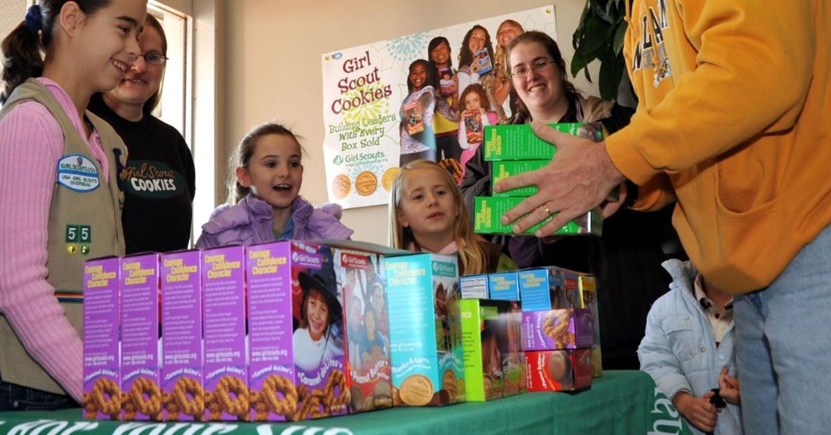 A Girl Scout selling Girl Scout cookies.