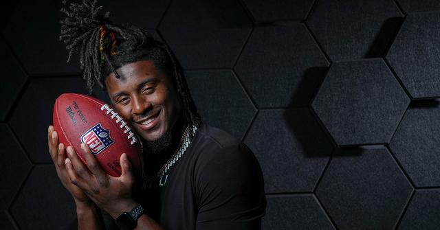 Kool-Aid McKinstry holding an NFL football