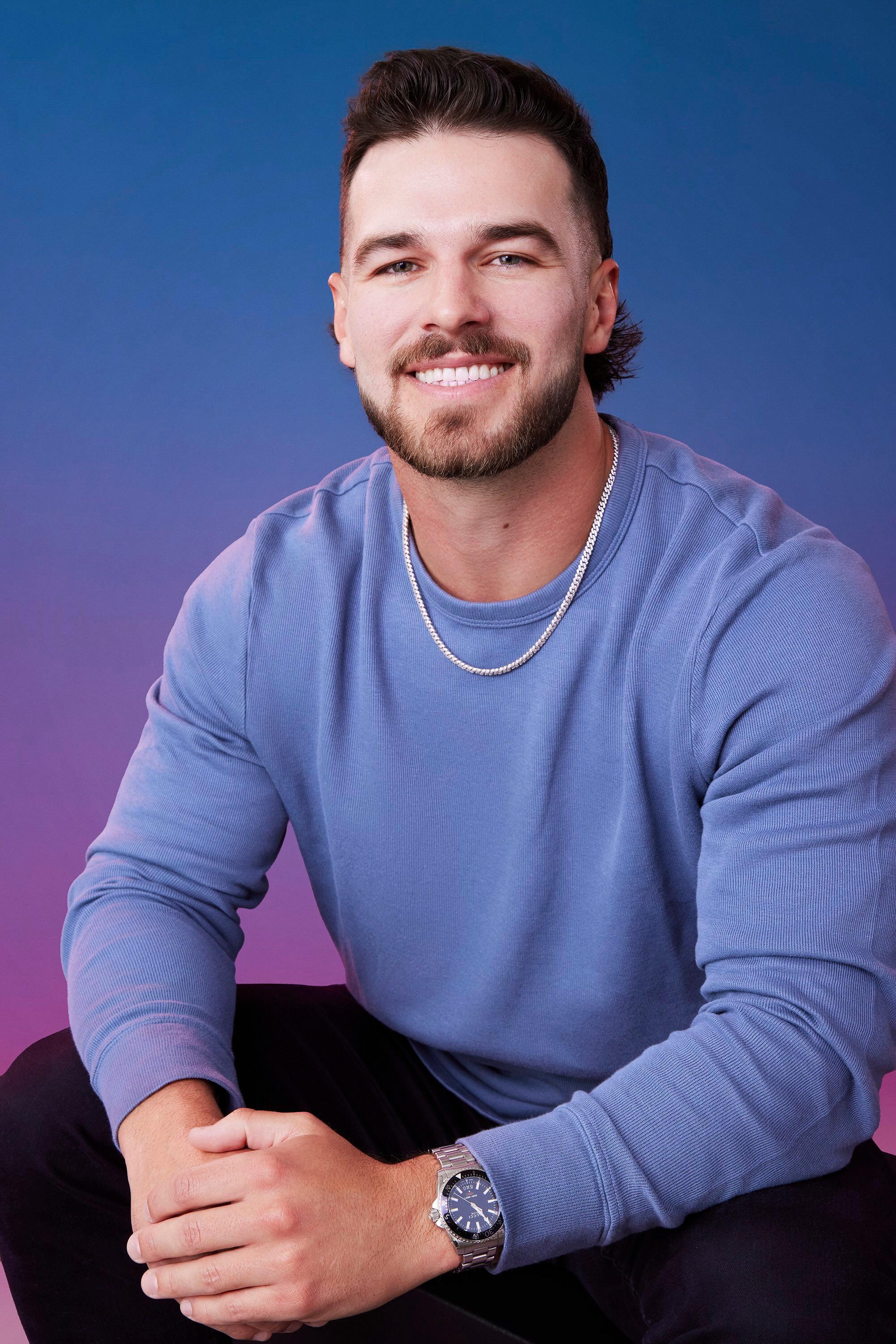 Austin poses in front of a blue-purple ombré background for his official 'The Bachelorette' Season 21 portrait.