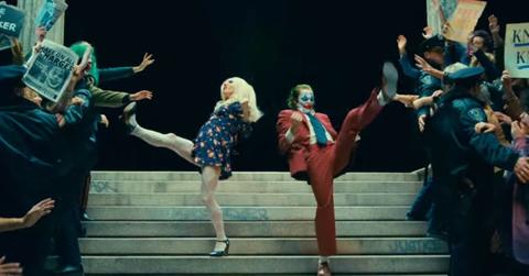 Lady Gaga and Joaquin Phoenix kicking on steps in ‘Joker: Folie a Deux.’