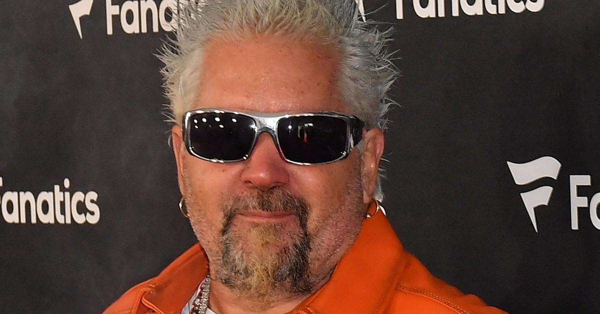 Guy Fieri in a orange shirt and sunglasses