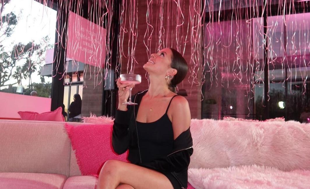 TarasWRLD holding a drink and looking up at pink balloons