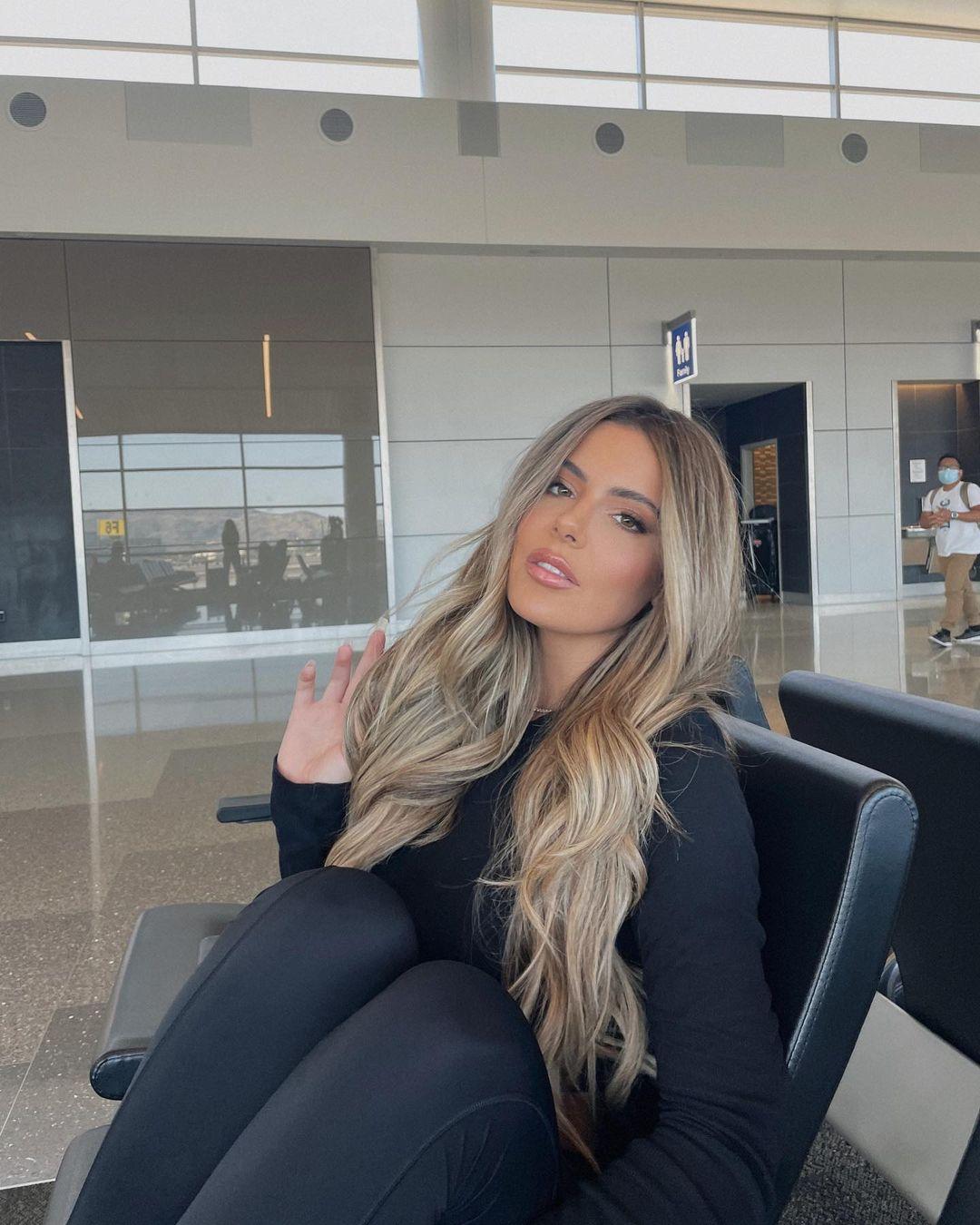 Brielle Bermann with blonde hair in a glamour shot at the airport.