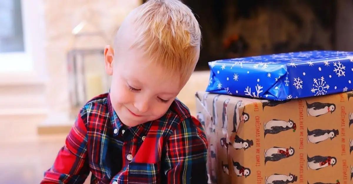 Myka Stauffer's son Radley sitting next to Christmas presents.