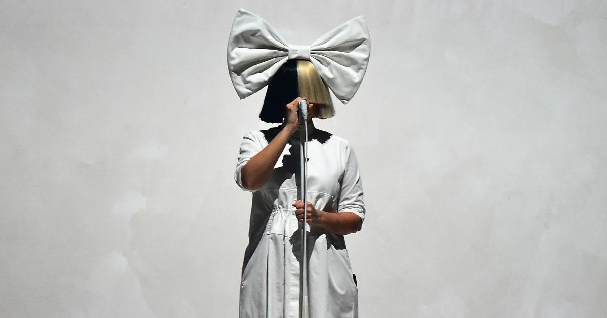 Sia covers her face with a split color wig, 