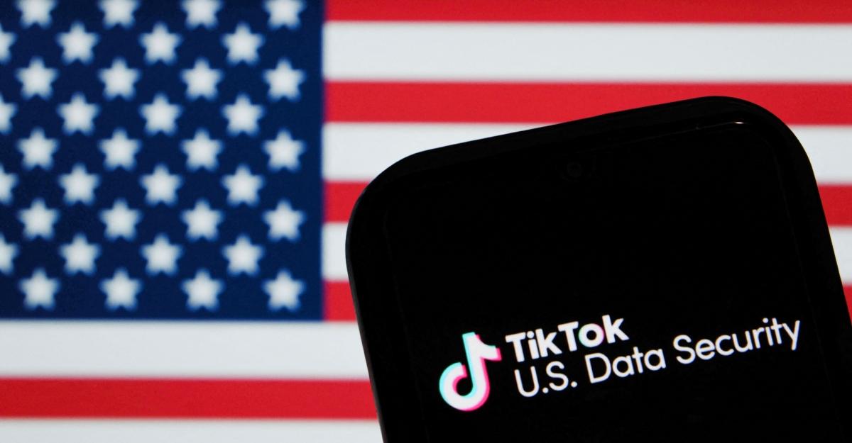 A phone showing TikTok U.S. Data Security in front of an American Flag