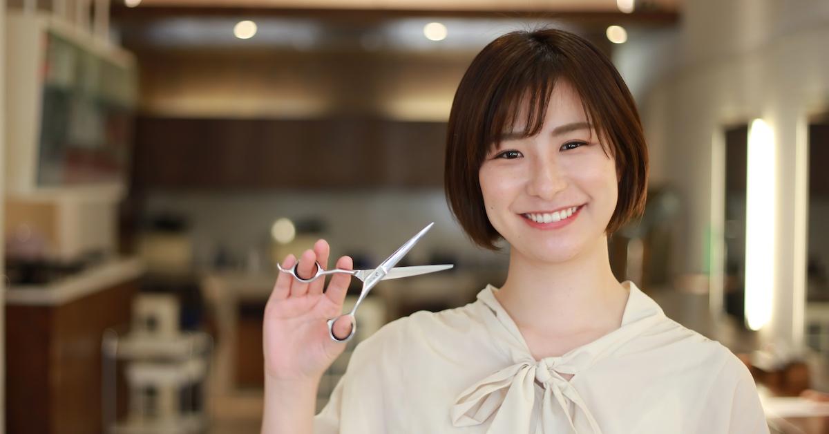 A hair stylist holding a pair of scissors
