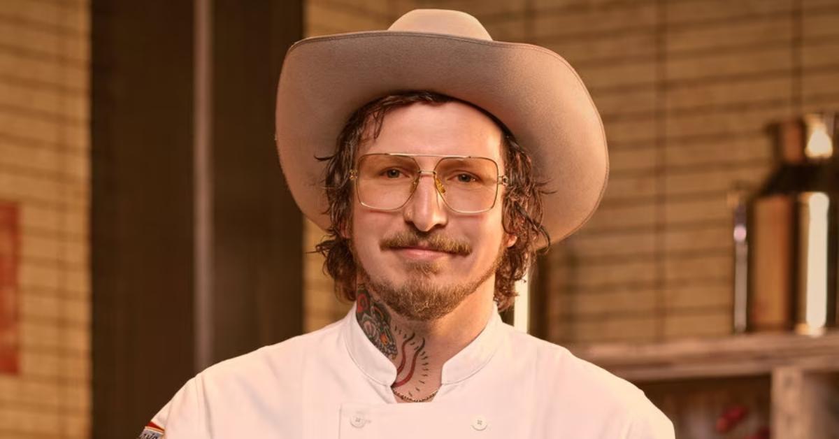 David Murphy wears a white chef's jacket, a cowboy hat, and glasses for his official portrait for 'Top Chef: Wisconsin.'