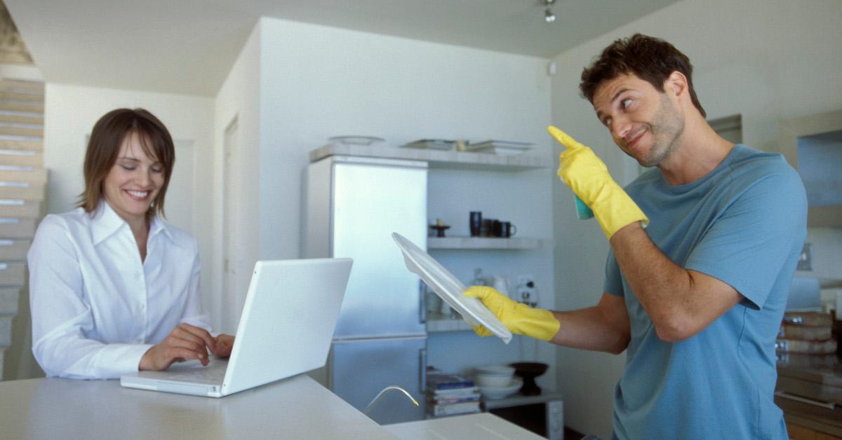 Man washing dishes and woman using laptop - stock photoRoommates