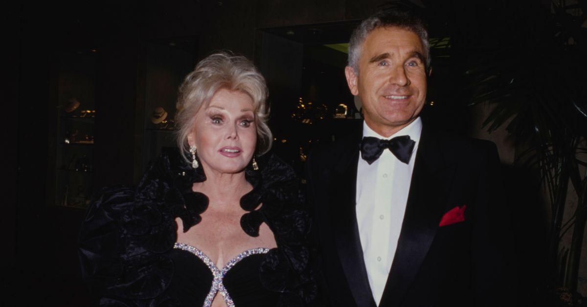 Zsa Zsa Gabor and her ninth husband, Prince Frederic Anhalt at an event in a black dress and black suit.