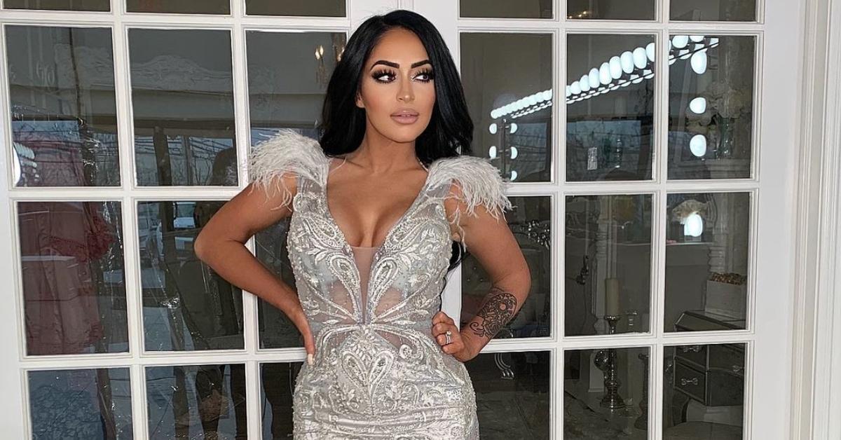 Angelina Pivarnick stands in front of double doors in a silver dress