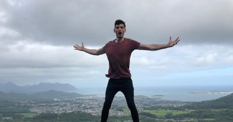 Ice Poseidon standing on a railing above the ocean in Hawaii