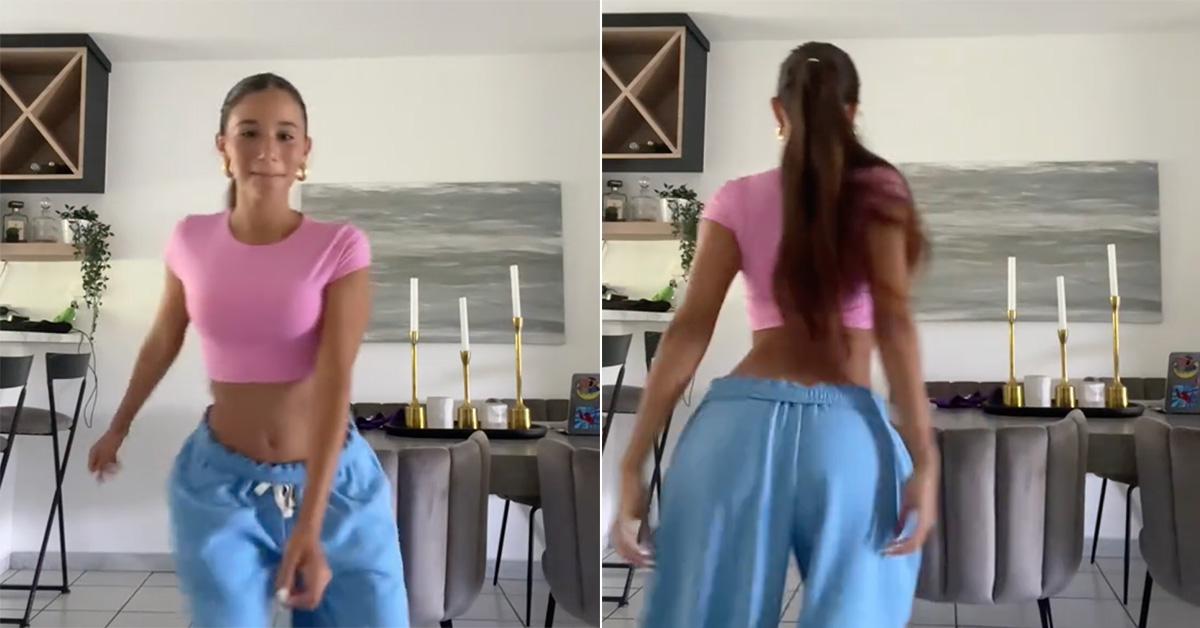 Lauren Sophia dancing in blue sweatpants and a pink crop top. 