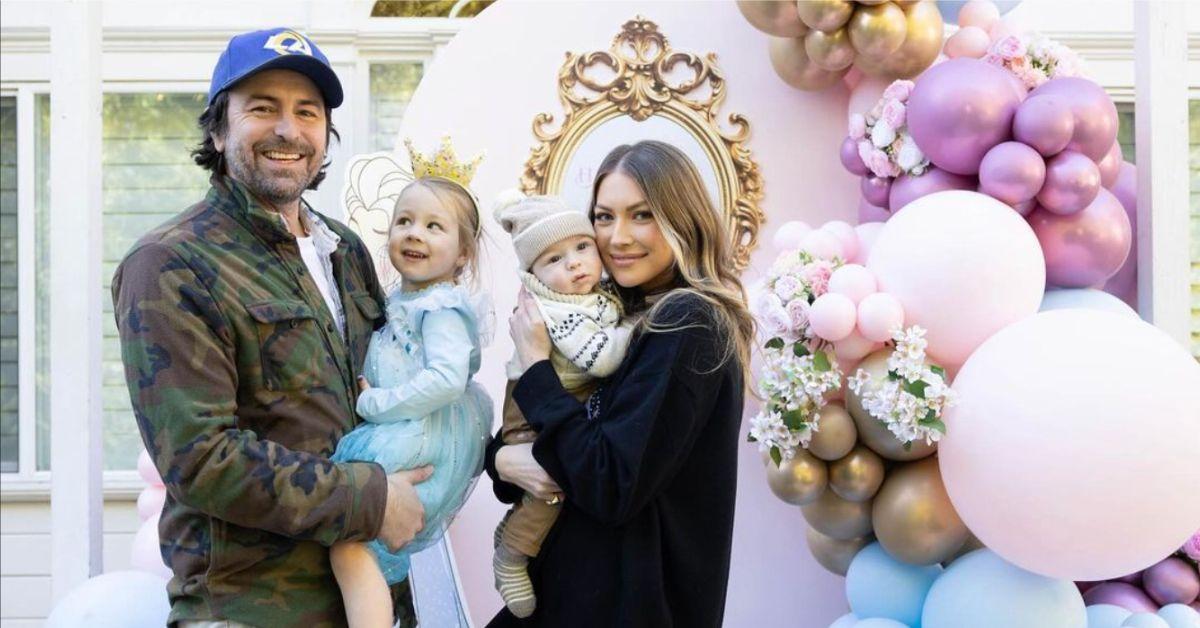 Beau Clark and Stassi Schroeder pose for a family photo as they each hold one of their daughters