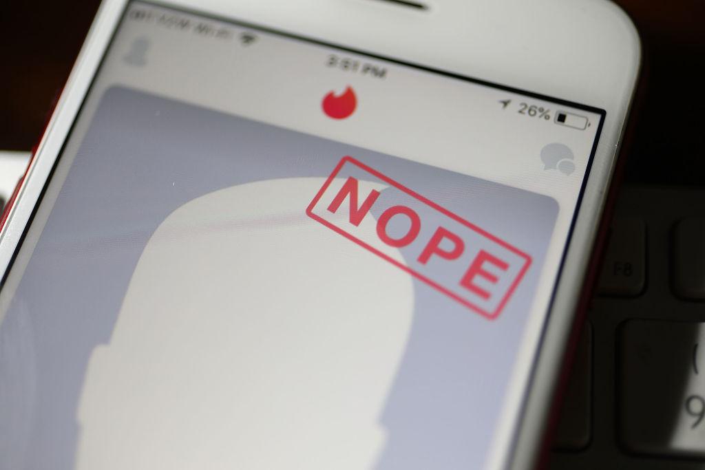 In this photo illustration, the dating app Tinder is seen on the screen of an iPhone