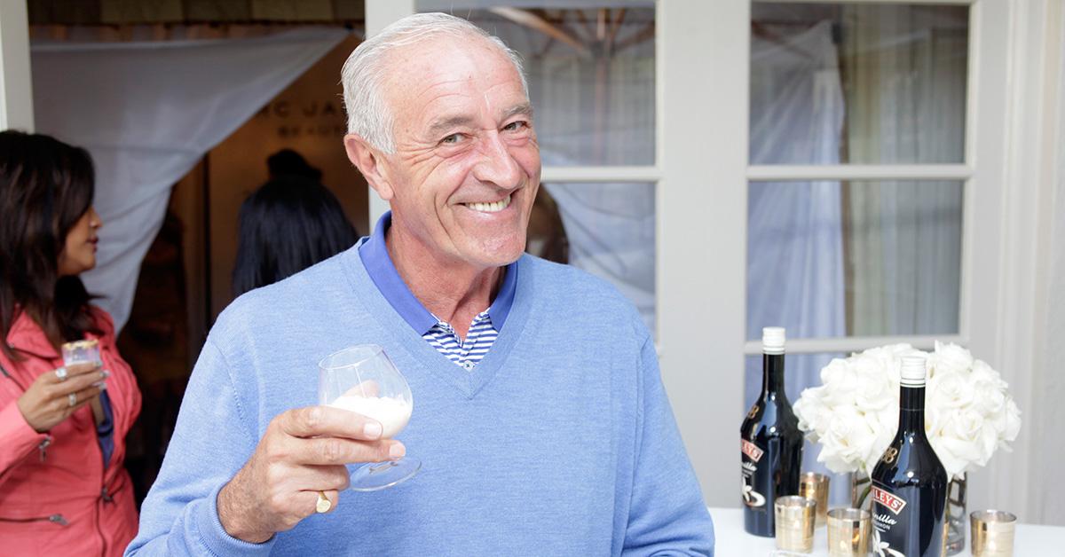 Len Goodman with a glass smiling at the camera. 